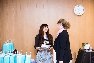 Two women chatting beside a table of gift bags