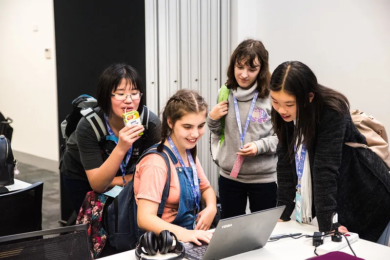 Girls gathered around a laptop
