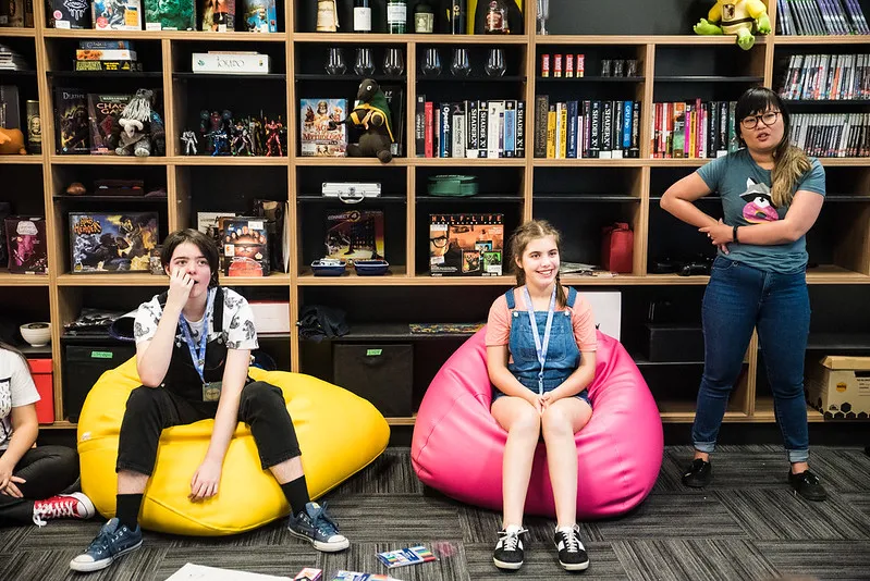 Participants on beanbags in front of a shelf of games and toys