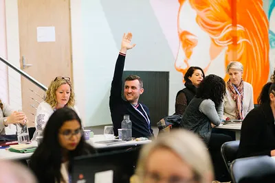 A participant raising her hand to ask a question