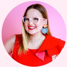 Sarah Moran in pink glasses and a red top