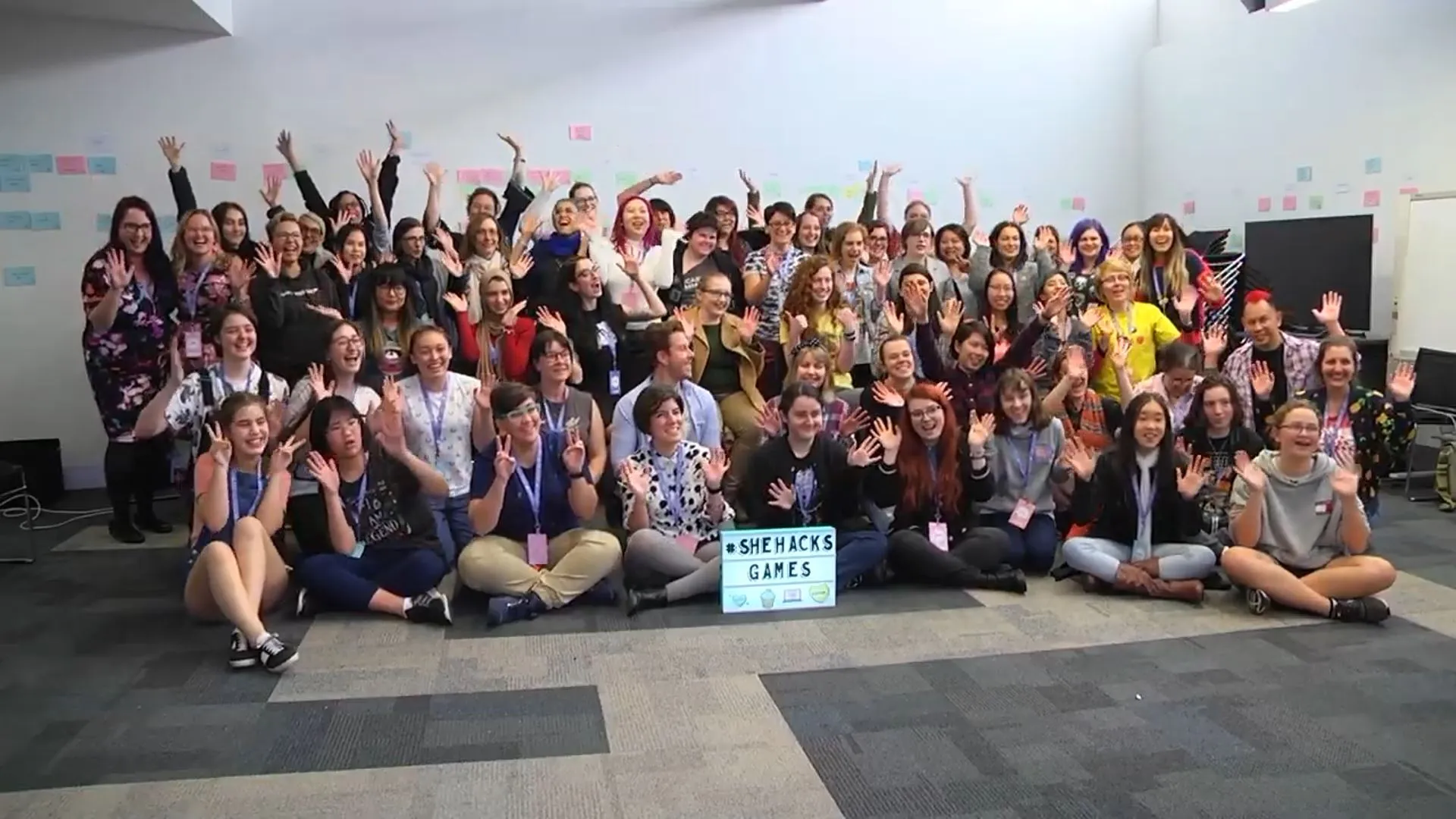 A huge group of girl geeks sitting together on the floor