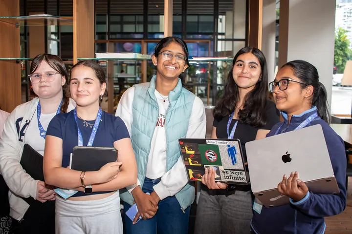 Students holding up their laptops